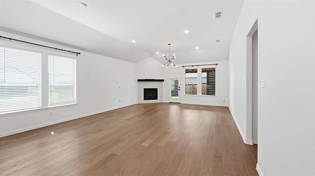 3129 Grayslick Avenue, Celina, TX 75009 Vaulted ceiling, recessed lighting, wood-finish flooring, fireplace, and a contemporary chandelier