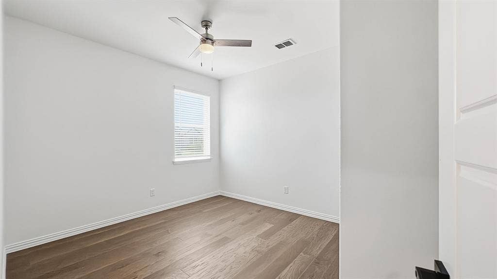 3129 Grayslick Avenue, Celina, TX 75009 Wood-finish flooring, neutral wall tones, ceiling fan with integrated lighting, window with blinds, and a paneled door