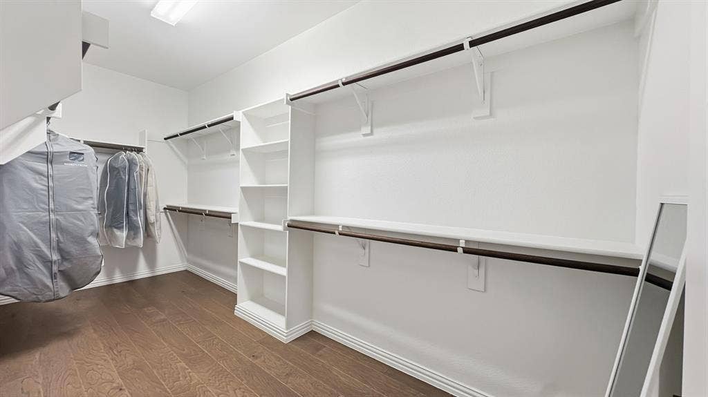 3129 Grayslick Avenue, Celina, TX 75009 Expansive walk-in closet featuring wood-finish flooring, white built-in shelving, and multiple hanging rods
