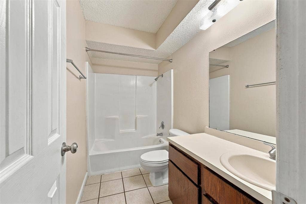 410 W Franklin Street, #5, Waxahachie, TX 75165 Full bathroom featuring a shower-tub combination, a vanity with a surface-mounted sink, and a large wall-mounted mirror