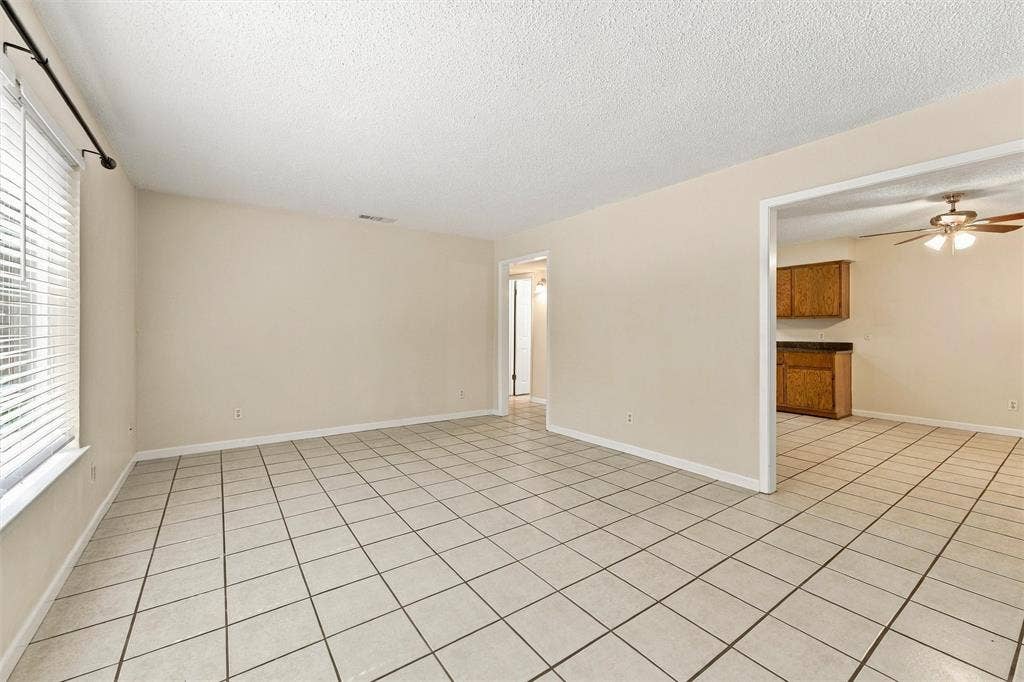 410 W Franklin Street, #5, Waxahachie, TX 75165 Spacious room featuring neutral wall paint, white tile flooring, and a window with blinds