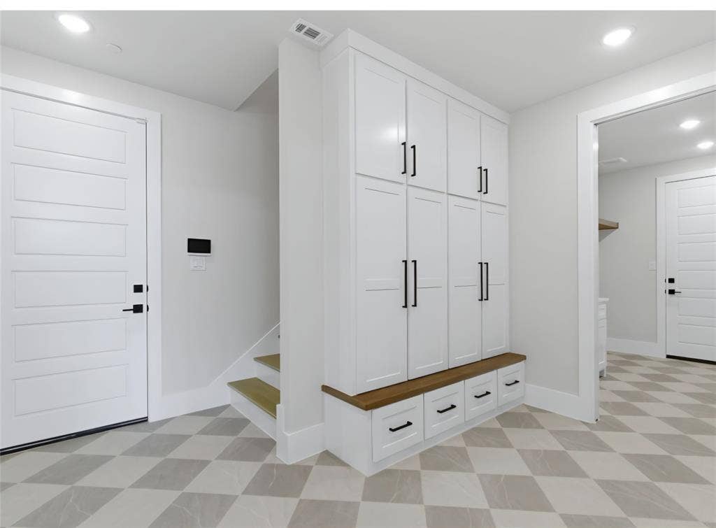 2608 Southbay, Northlake, TX 76226 Built-in storage cabinetry with a wood-finish benchtop, contrasting matte black hardware, and patterned floor tile