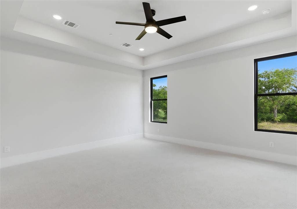 2608 Southbay, Northlake, TX 76226 Recessed lighting, ceiling fan, tray ceiling, two windows with black frames, and light-toned carpet