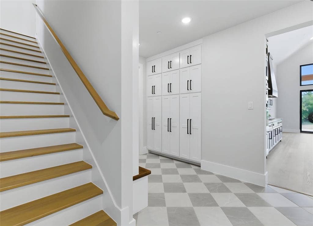 2608 Southbay, Northlake, TX 76226 Hardwood staircase with a wood-finish handrail, checkered tile flooring, built-in white cabinetry with matte black hardware, and recessed lighting