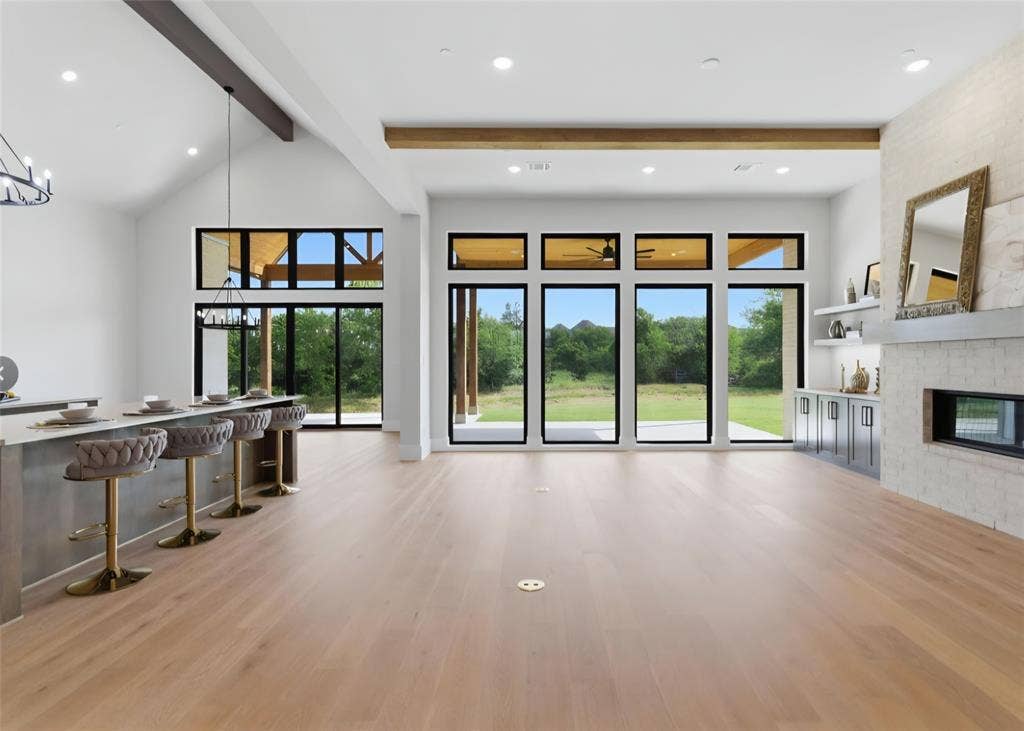 2608 Southbay, Northlake, TX 76226 Expansive living area with light wood-finish flooring, vaulted ceilings, and a built-in wet bar