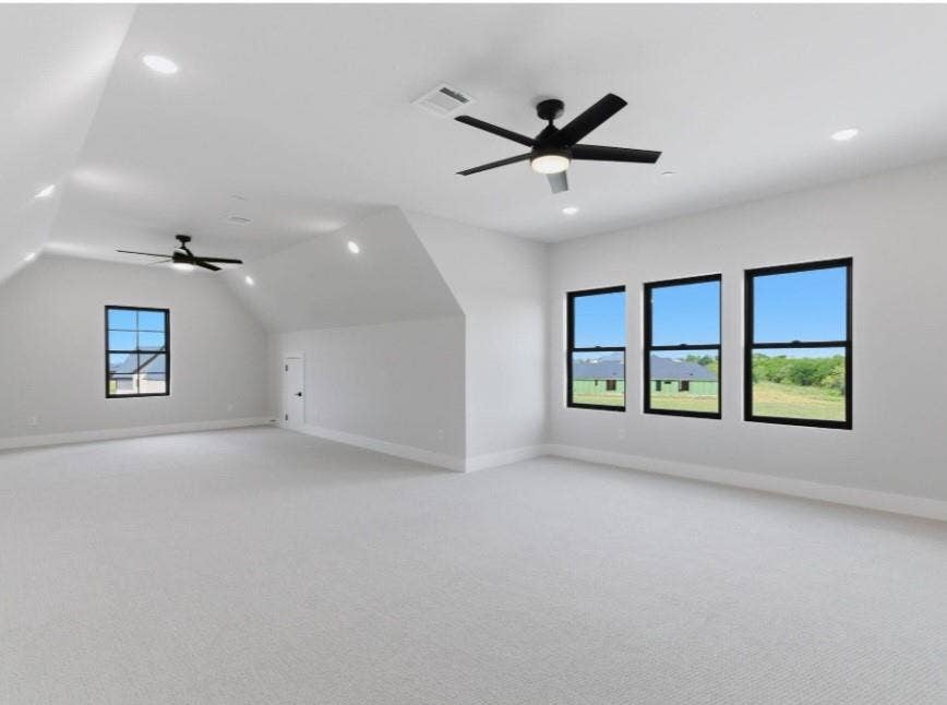 2608 Southbay, Northlake, TX 76226 Expansive room featuring vaulted ceilings, recessed lighting, ceiling fans, multiple windows with dark frames, and light-toned carpeting