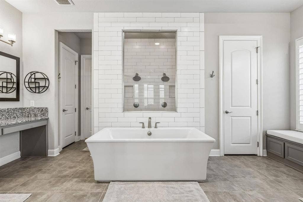 7342 Shoestring Drive, Frisco, TX 75036 Luxurious primary retreat featuring a spa-inspired bath with a soaking tub and oversized dual-head shower.