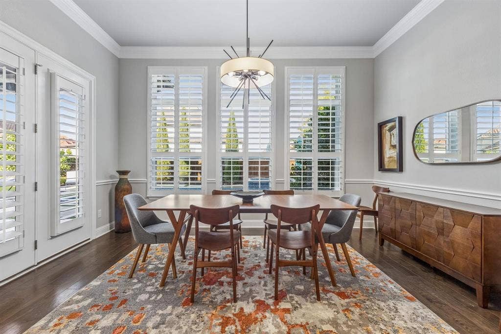 7342 Shoestring Drive, Frisco, TX 75036 Dining area featuring plantation shutters, overlooking the resort-style pool and seamlessly connecting to the covered outdoor living area.