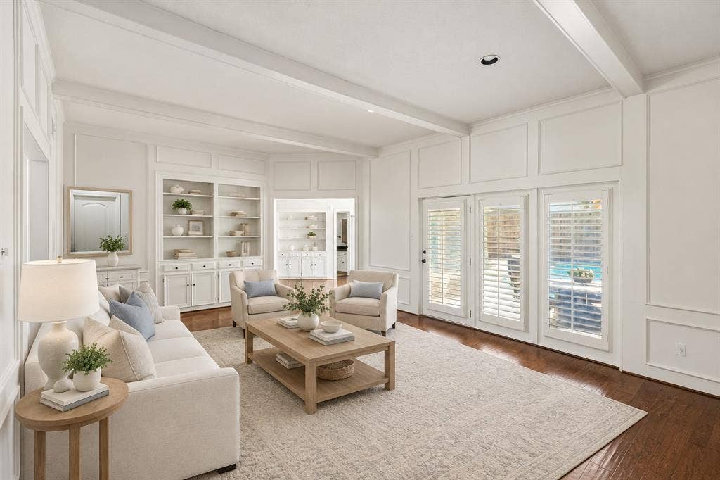 10322 White Rock Place, Dallas, TX 75238 Bright, open-concept main living room featuring coffered ceilings, hardwoods, and abundant natural light from multiple French doors with plantation shutters. This photo is virtually staged.