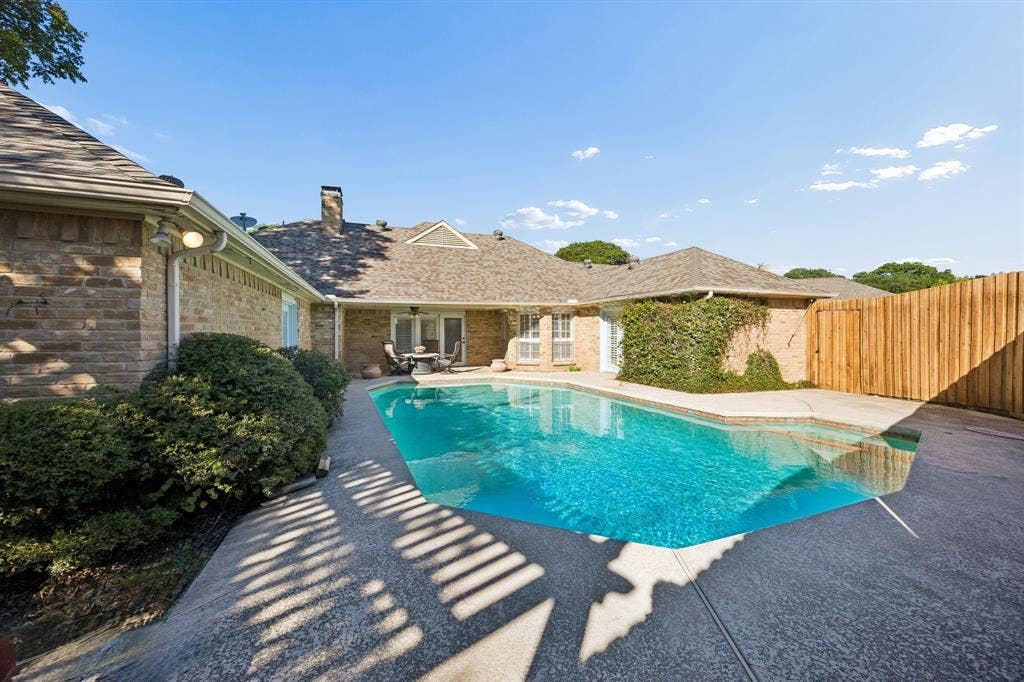 10322 White Rock Place, Dallas, TX 75238 Inviting swimming pool with integrated spa, covered porch, and new fence.