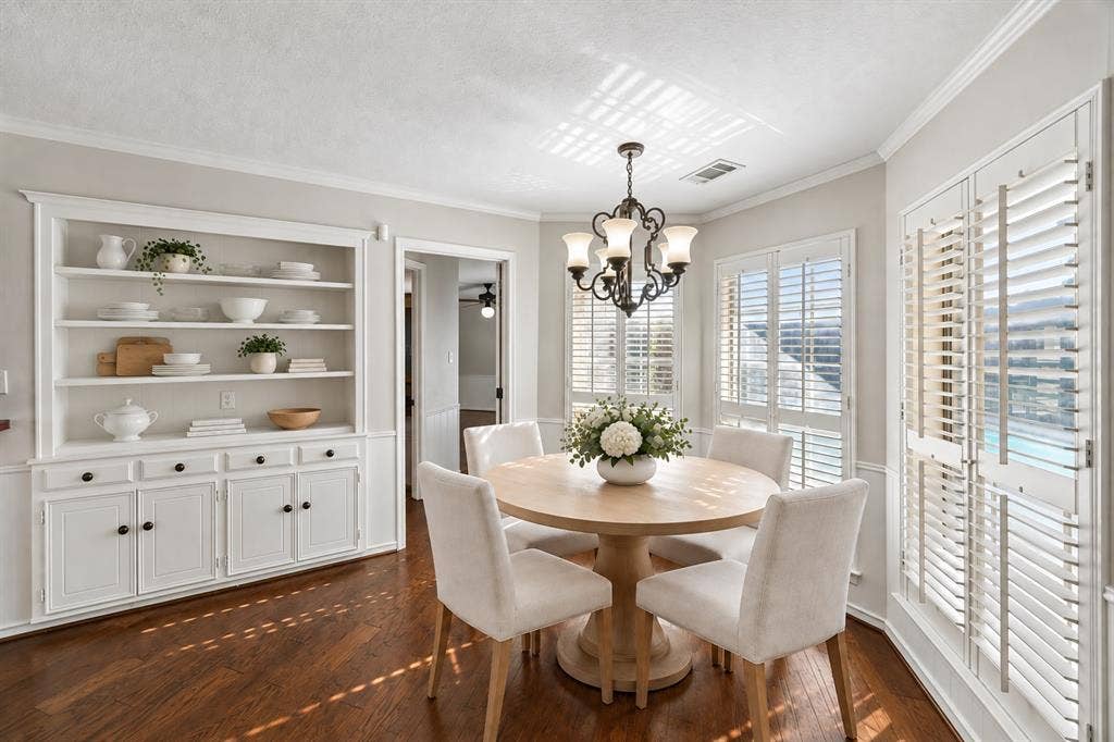 10322 White Rock Place, Dallas, TX 75238 Eat-in kitchen with built-in hutch and overlooking pool. This photo is virtually staged.