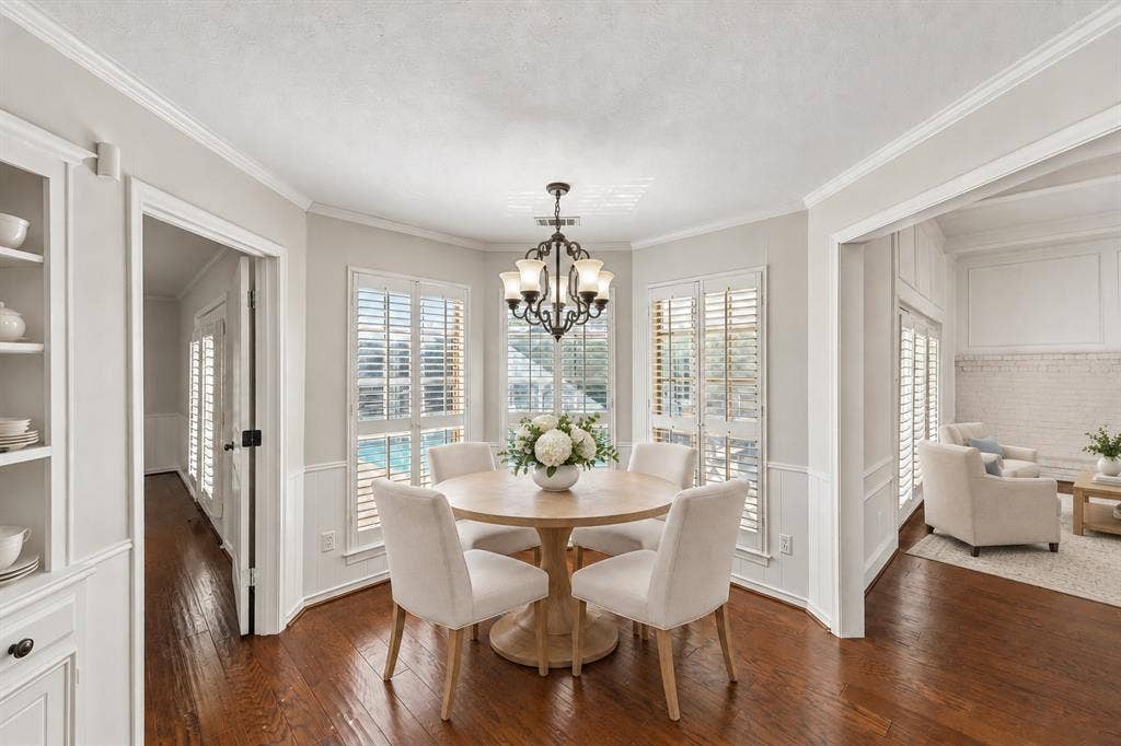 10322 White Rock Place, Dallas, TX 75238 Eat-in kitchen breakfast area with built-in hutch, beautiful hardwoods, and overlooking pool. This photo is virtually staged.