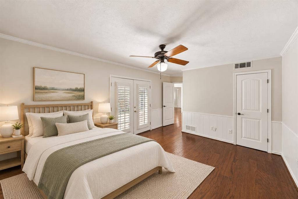10322 White Rock Place, Dallas, TX 75238 Spacious guest bedroom featuring hardwoods, french doors, walk-in closet and en suite bath. This photo is virtually staged.