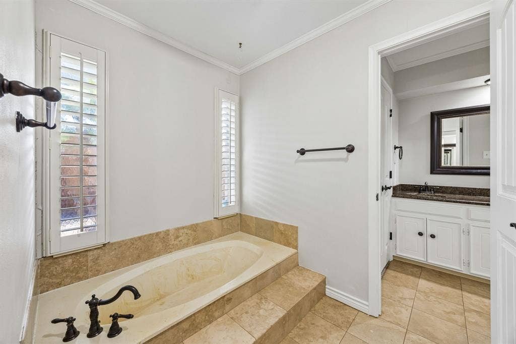 10322 White Rock Place, Dallas, TX 75238 Primary bath featuring separate vanities and closets, and separate tub and walk-in shower.