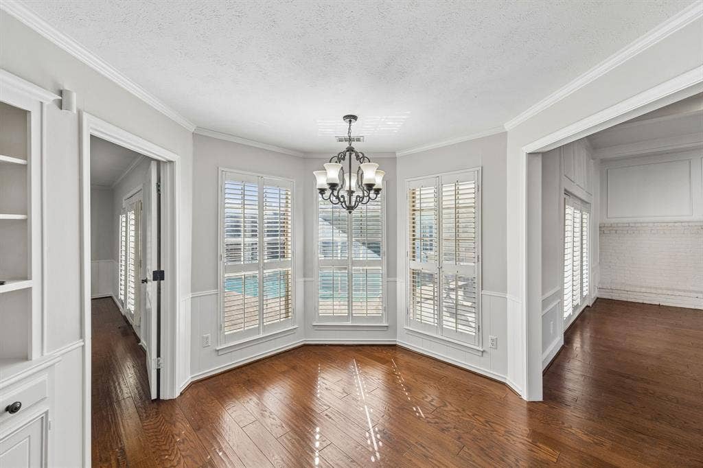 10322 White Rock Place, Dallas, TX 75238 Breakfast room features hardwood flooring, built-in hutch, and overlooks the sparkling pool.