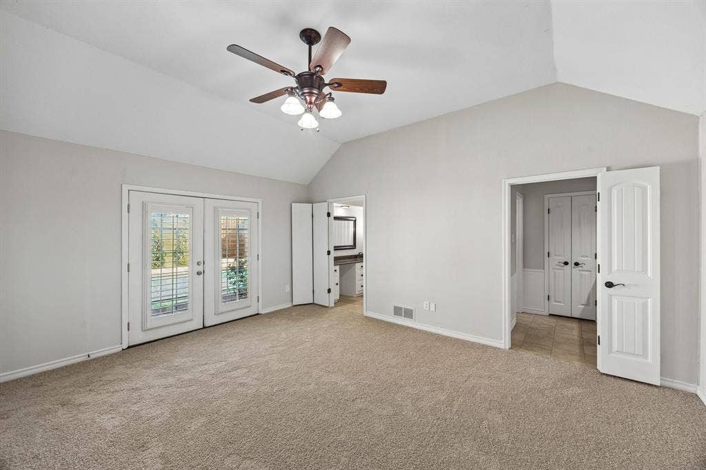 10322 White Rock Place, Dallas, TX 75238 Spacious primary bedroom featuring vaulted ceilings, new carpet, and ensuite bath with separate vanities.