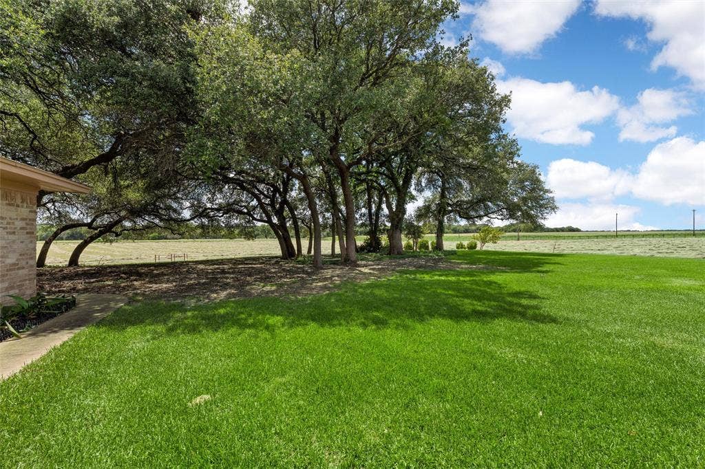 2029 Speegleville Road, Woodway, TX 76712 Expansive green lawn with mature trees and a brick exterior