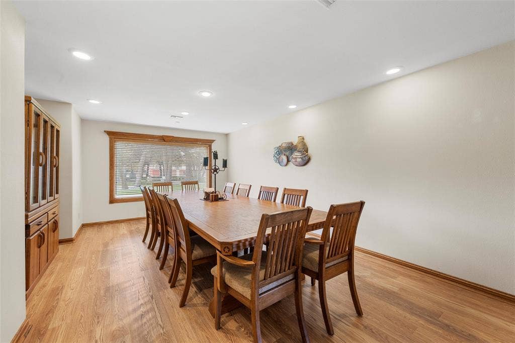 2029 Speegleville Road, Woodway, TX 76712 Spacious dining area featuring wood-finish flooring, recessed lighting, a large window with wood trim, and a built-in display cabinet