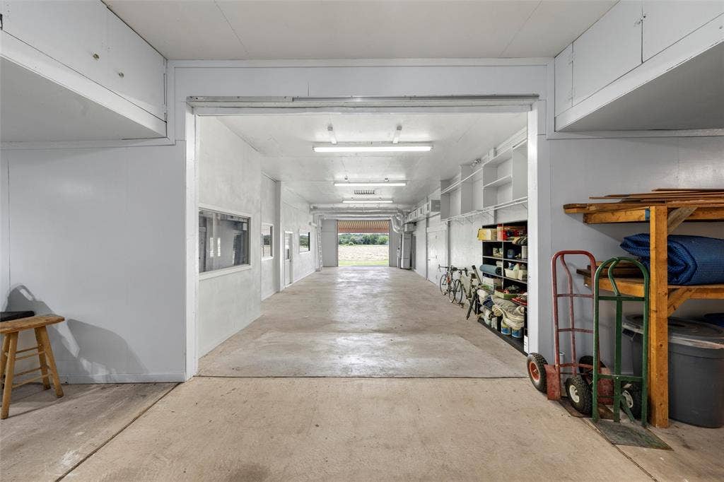 2029 Speegleville Road, Woodway, TX 76712 Spacious utility area with concrete flooring, overhead fluorescent lighting, and built-in shelving