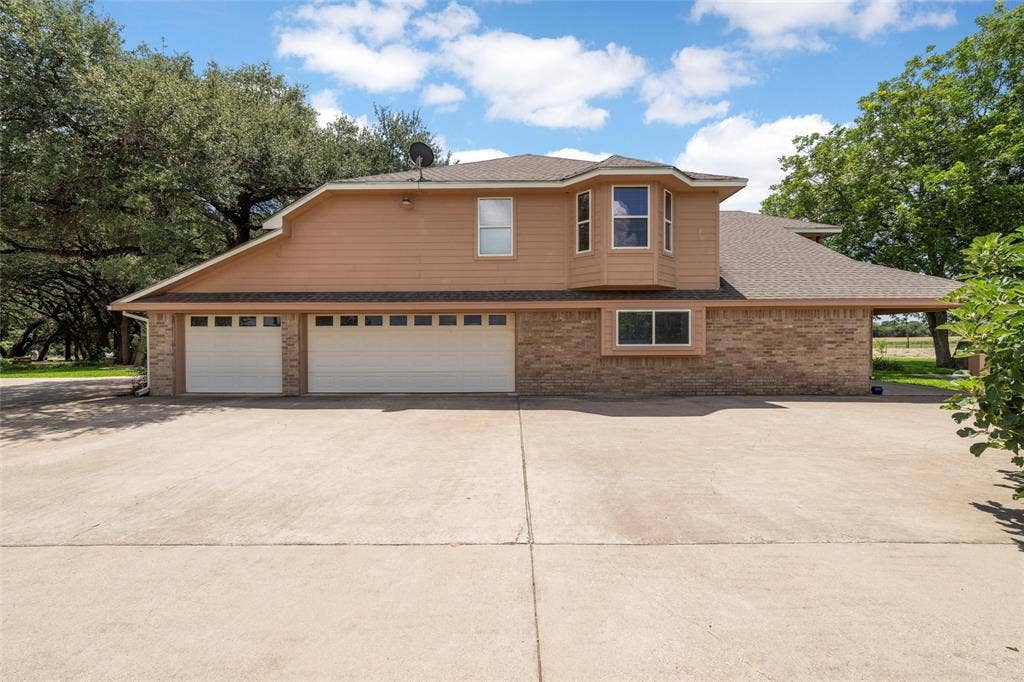 2029 Speegleville Road, Woodway, TX 76712 Two-story facade with a multi-car garage, brick and siding exterior, and a bay window feature