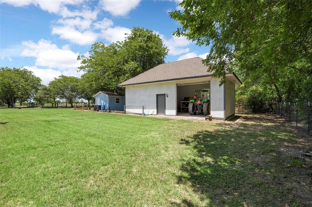 2029 Speegleville Road, Woodway, TX 76712 Expansive grass lawn with a detached storage building, a separate utility shed, and mature trees