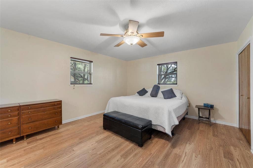 2029 Speegleville Road, Woodway, TX 76712 Wood-finish flooring, ceiling fan, and two windows with blinds