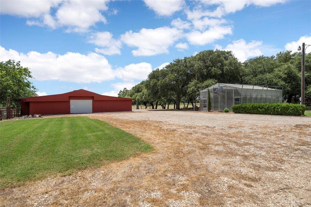 2029 Speegleville Road, Woodway, TX 76712 Red barn structure, gravel yard, glass greenhouse, manicured shrubbery, mature trees