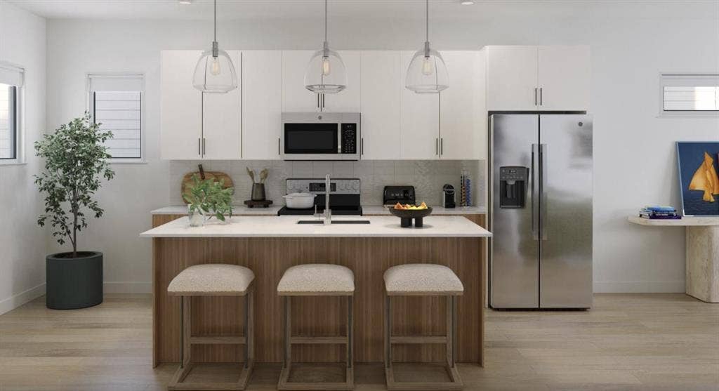 9032 Prairie Path, #3404, Rowlett, TX 75089 Kitchen with stainless steel appliances, light wood-type flooring, pendant lighting, decorative backsplash, and a kitchen island with sink