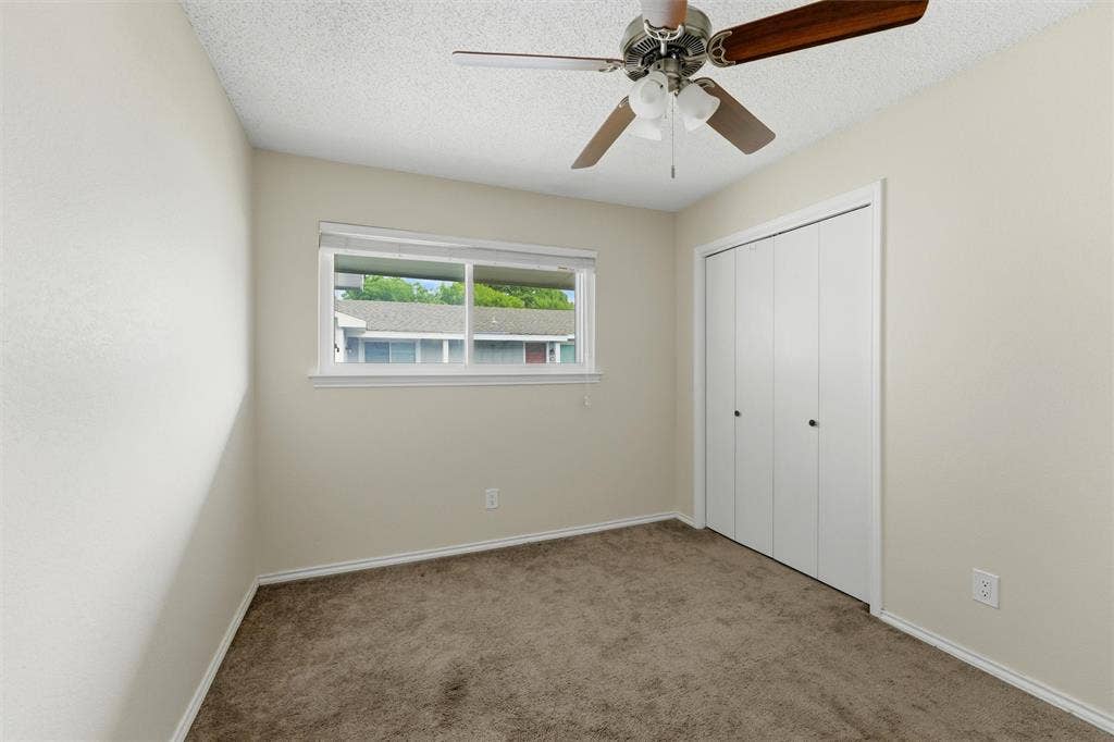 401 N 7th Street, #C, Midlothian, TX 76065 Carpeted room featuring a ceiling fan with light fixture, a window with white trim, and a bi-fold closet