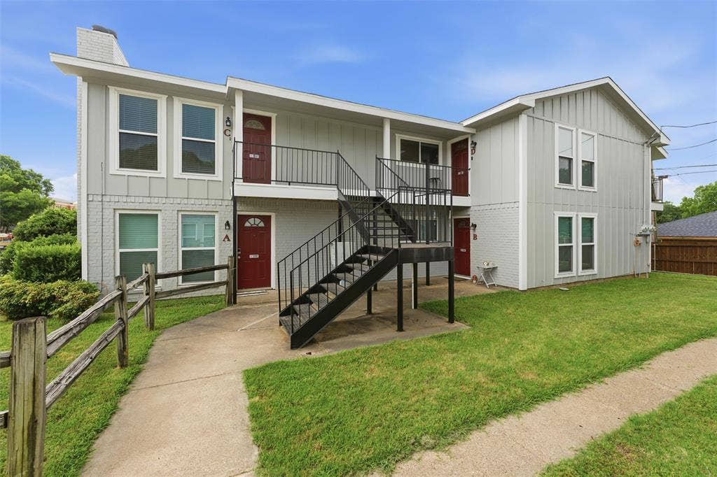 401 N 7th Street, #C, Midlothian, TX 76065 Multi-unit building featuring a light gray exterior, red entry doors, and black metal stairways
