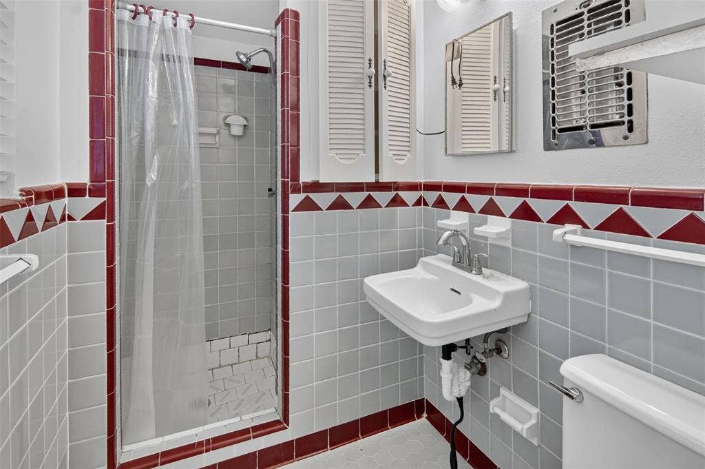 2024 Blake Avenue, Dallas, TX 75228 Pedestal sink with chrome fixtures, tiled shower stall, and patterned wall tiling
