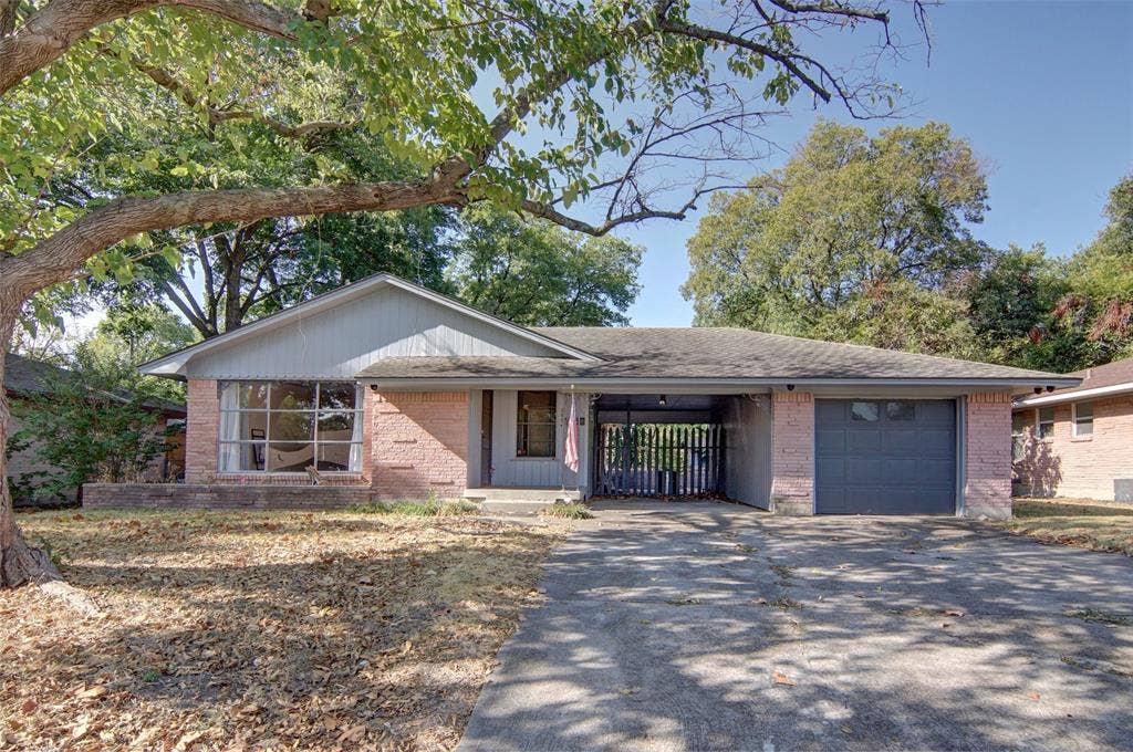 2024 Blake Avenue, Dallas, TX 75228 Brick exterior with a gray garage door, covered carport, and a prominent front-facing window