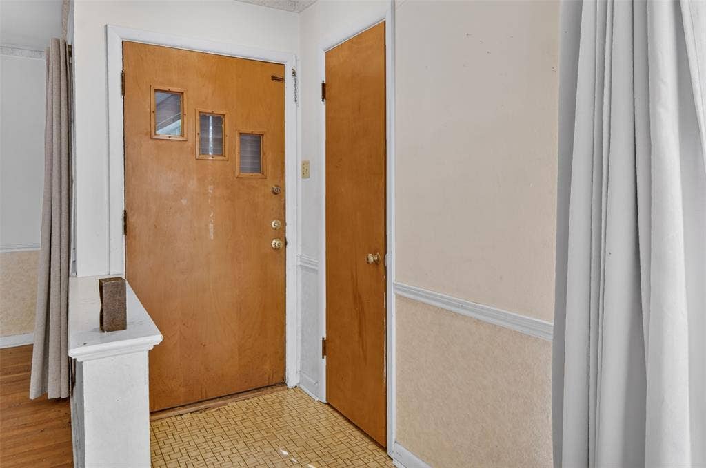 2024 Blake Avenue, Dallas, TX 75228 Hardwood entry door with three inset windows, patterned floor tiling, and neutral wall tones
