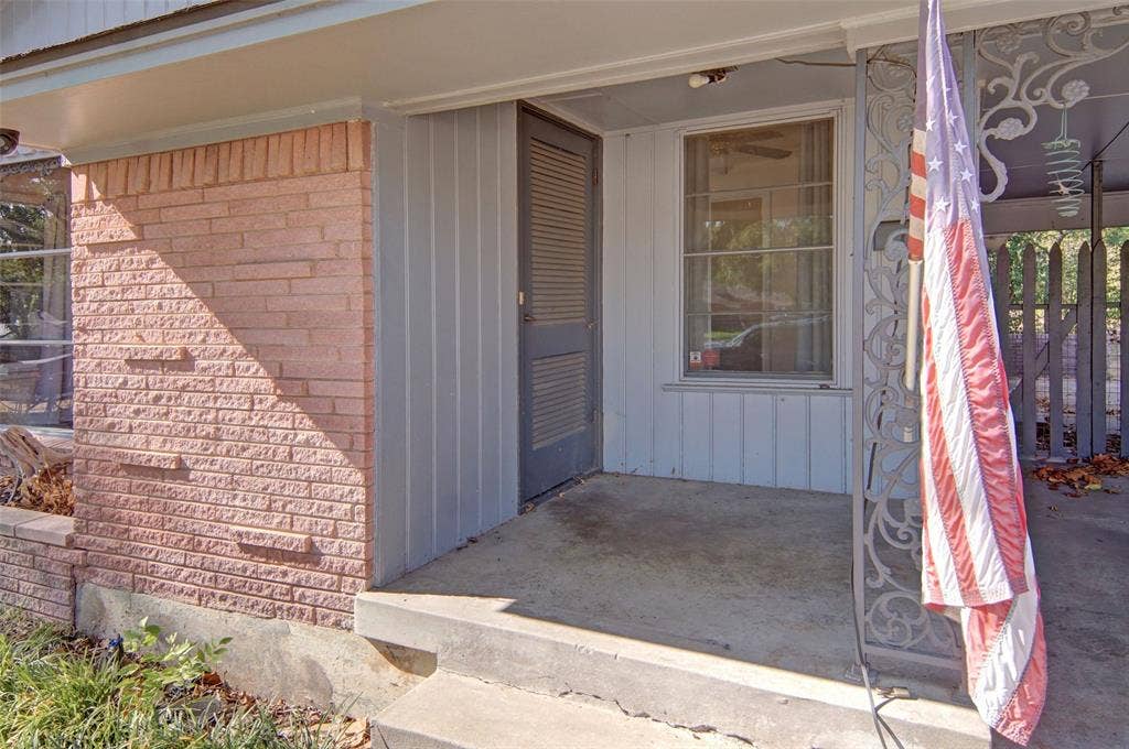 2024 Blake Avenue, Dallas, TX 75228 Brick facade with vertical siding, covered concrete porch, and decorative wrought iron column