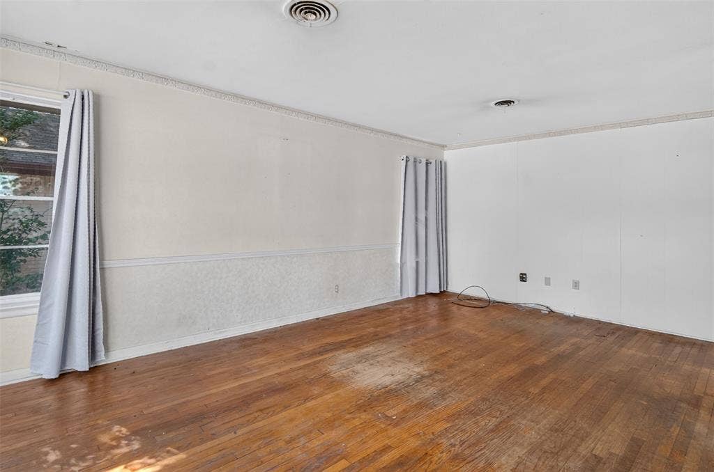 2024 Blake Avenue, Dallas, TX 75228 Hardwood flooring, crown molding, chair rail molding, and a window with trim