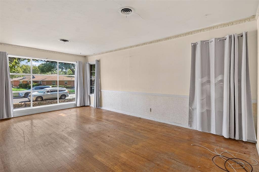2024 Blake Avenue, Dallas, TX 75228 Expansive front window with multiple panes, wood-finish flooring, textured wainscoting, decorative ceiling trim, and multiple wall outlets