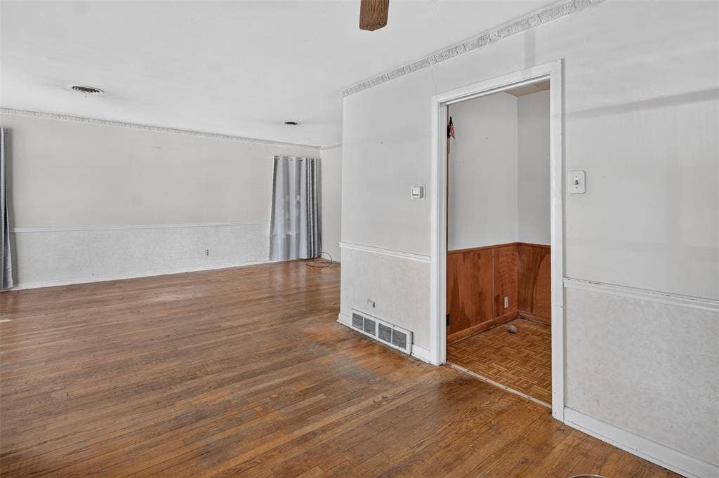 2024 Blake Avenue, Dallas, TX 75228 Wood-finish flooring, white walls, decorative crown molding, and white chair rail with textured panels