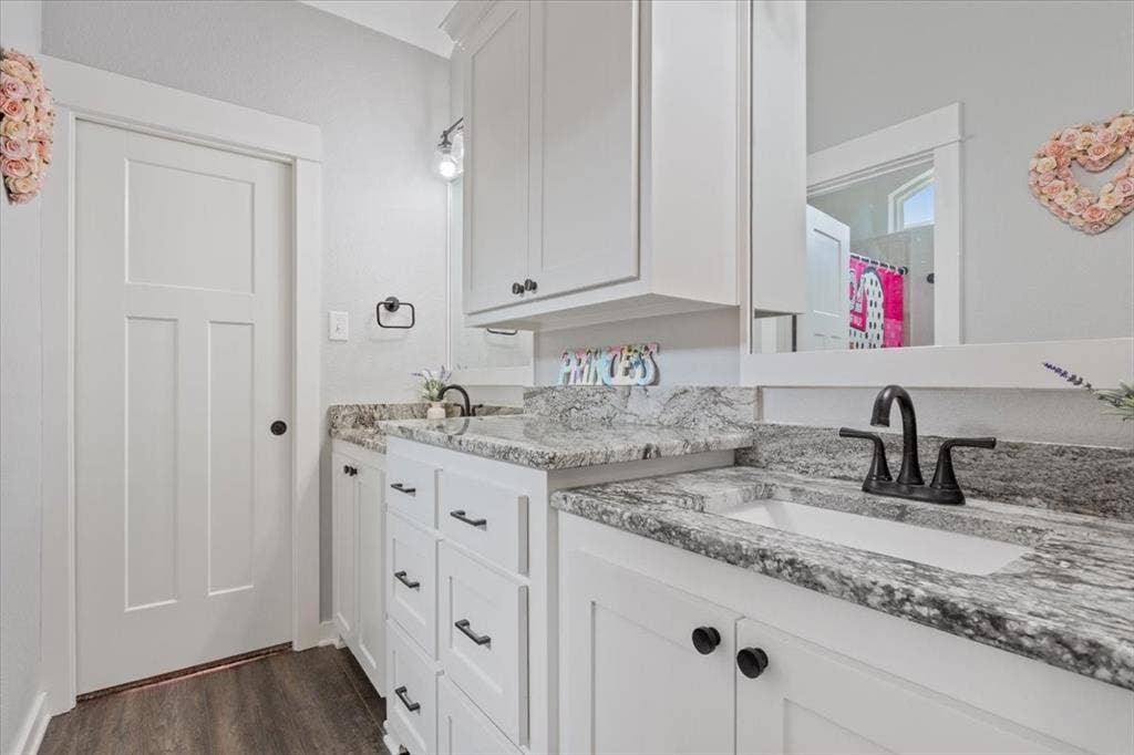 10305 Creekside Lane, Waco, TX 76712 Dual vanity with under-mount sinks, speckled countertops, white cabinetry, and matte black hardware