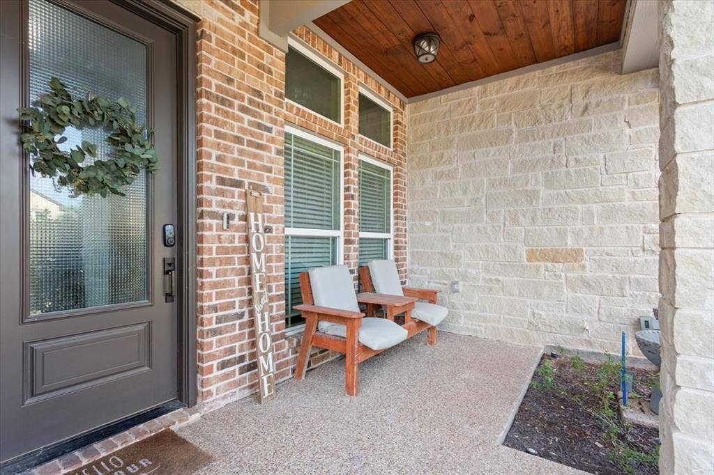 10305 Creekside Lane, Waco, TX 76712 Brick and stone exterior with a textured glass front door, covered porch, and wood-paneled ceiling