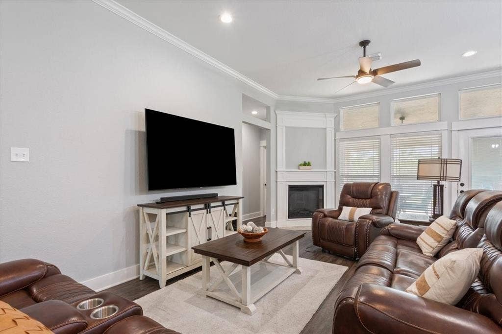10305 Creekside Lane, Waco, TX 76712 Recessed lighting, crown molding, wood-finish flooring, ceiling fan, and corner fireplace with mantel
