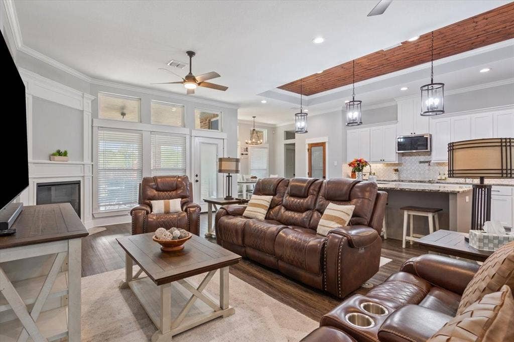 10305 Creekside Lane, Waco, TX 76712 Living area featuring wood-finish flooring, a fireplace with a white mantel, and ceiling fan