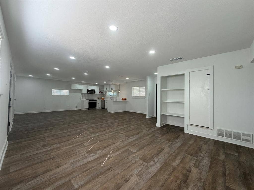 1424 E Parker Road, Plano, TX 75074 Open-concept living space featuring recessed lighting, wood-finish flooring, and built-in shelving