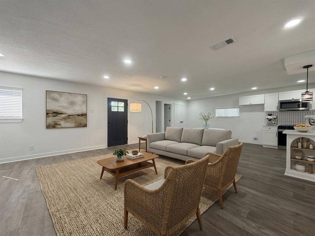 1424 E Parker Road, Plano, TX 75074 Recessed lighting throughout, wood-finish flooring, white cabinetry, dark gray entry door with glass panels, and stainless steel appliances