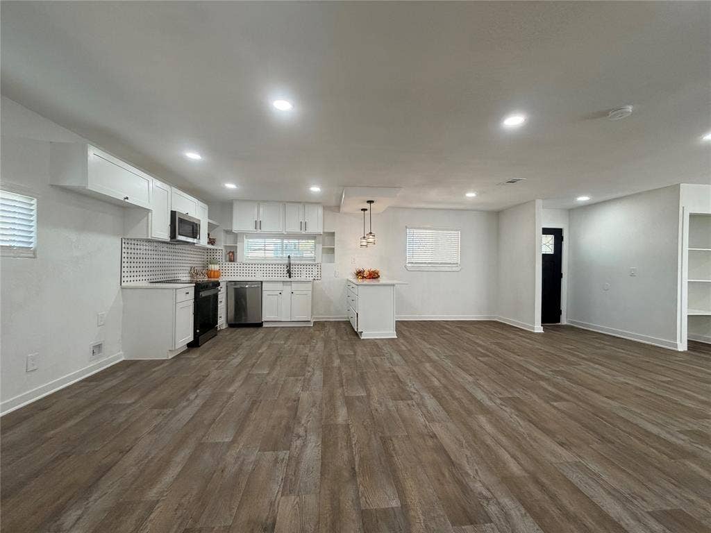 1424 E Parker Road, Plano, TX 75074 Open-concept living space with wood-finish flooring, white cabinetry, stainless steel appliances, and recessed lighting