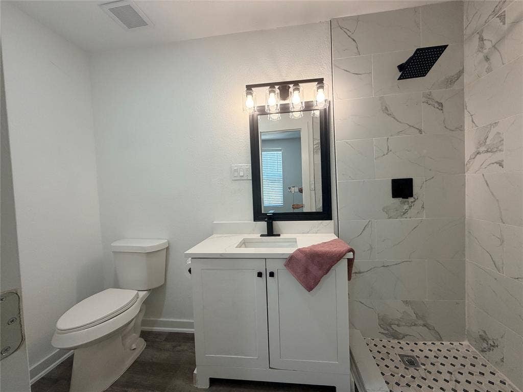 1424 E Parker Road, Plano, TX 75074 Vanity with white shaker cabinetry, white countertop, and black faucet