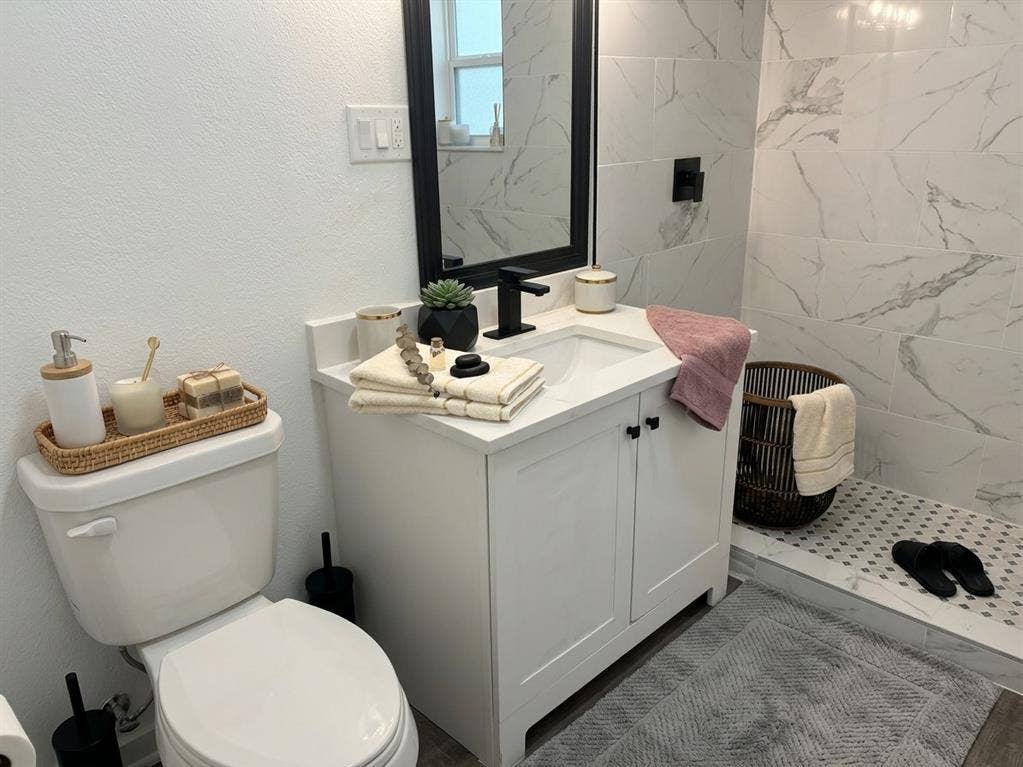 1424 E Parker Road, Plano, TX 75074 White vanity with two cabinet doors, an integrated sink, and a quartz-finish countertop