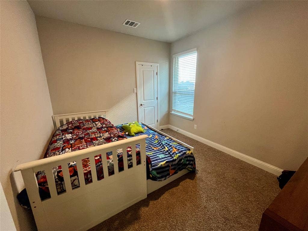 3636 Wintergreen Street, Grand Prairie, TX 76065 Neutral wall paint, window with horizontal blinds, white trim, and brown carpet