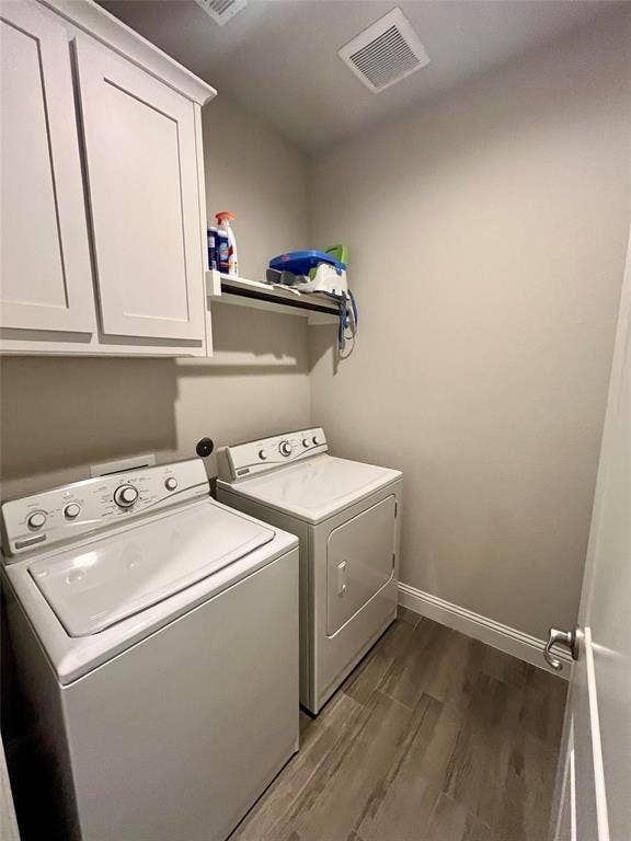 3636 Wintergreen Street, Grand Prairie, TX 76065 Laundry area featuring wood-look tile flooring, white shaker-style cabinetry, and a ceiling-mounted ventilation system