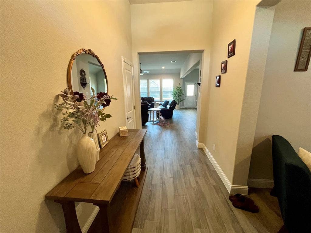 3636 Wintergreen Street, Grand Prairie, TX 76065 Hallway featuring light-toned walls, wood-finish flooring, and white trim