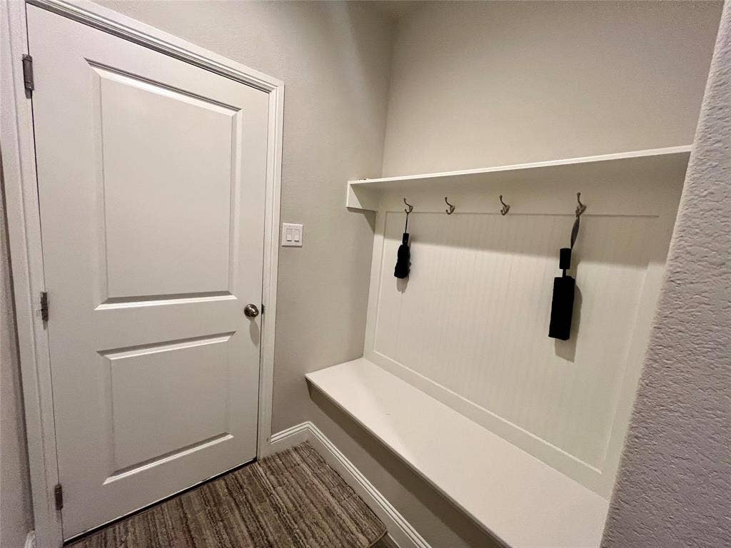 3636 Wintergreen Street, Grand Prairie, TX 76065 Built-in storage bench with beadboard paneling, wall-mounted hooks, and overhead shelving